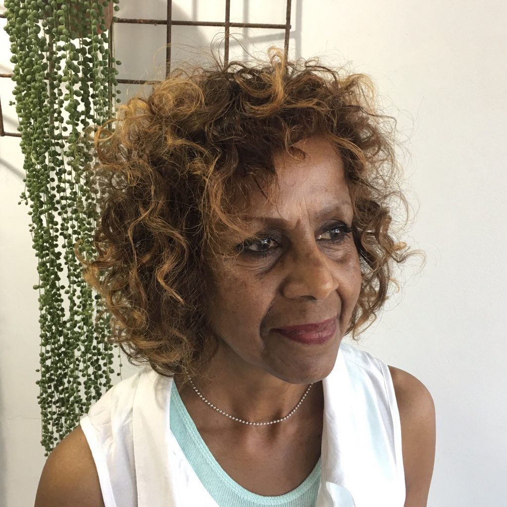 woman with short curly hair smiling