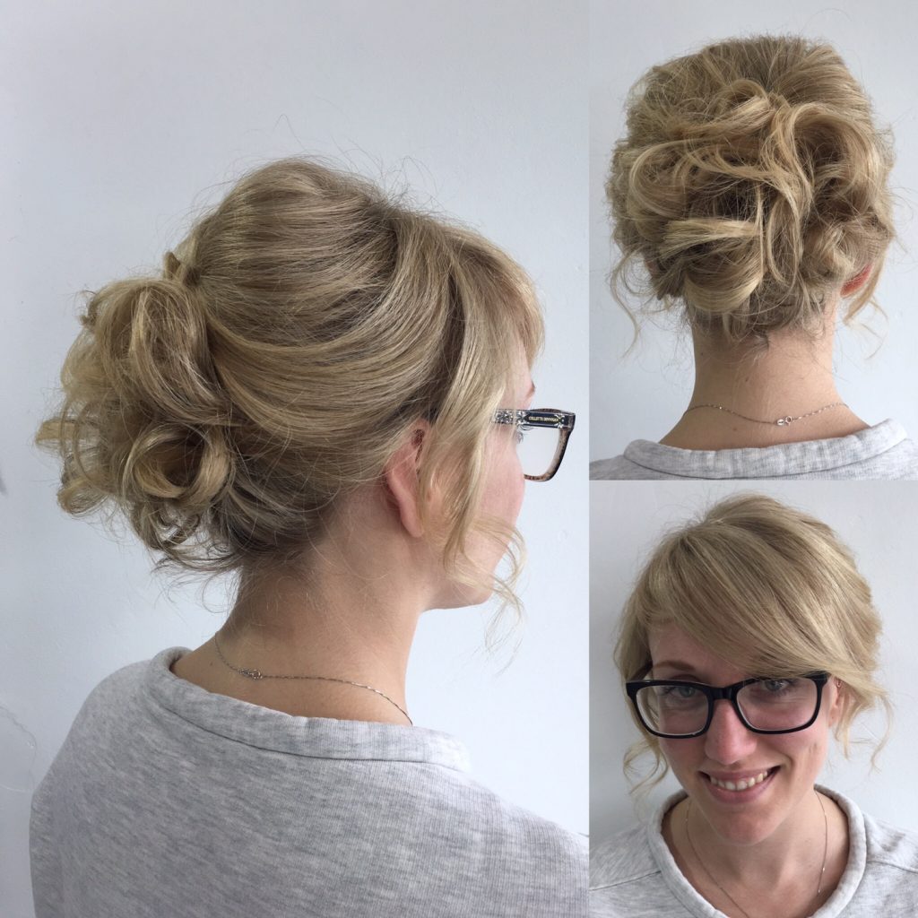 woman smiling wearing glasses with bun hairstyle