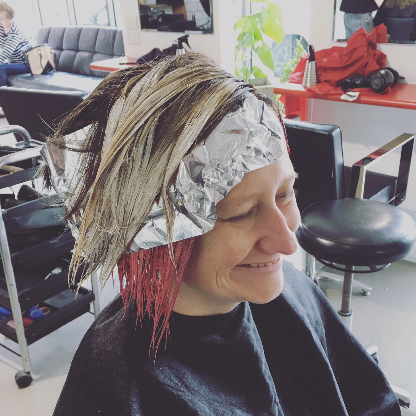 woman smiling and getting her hair done at delilah hair salon