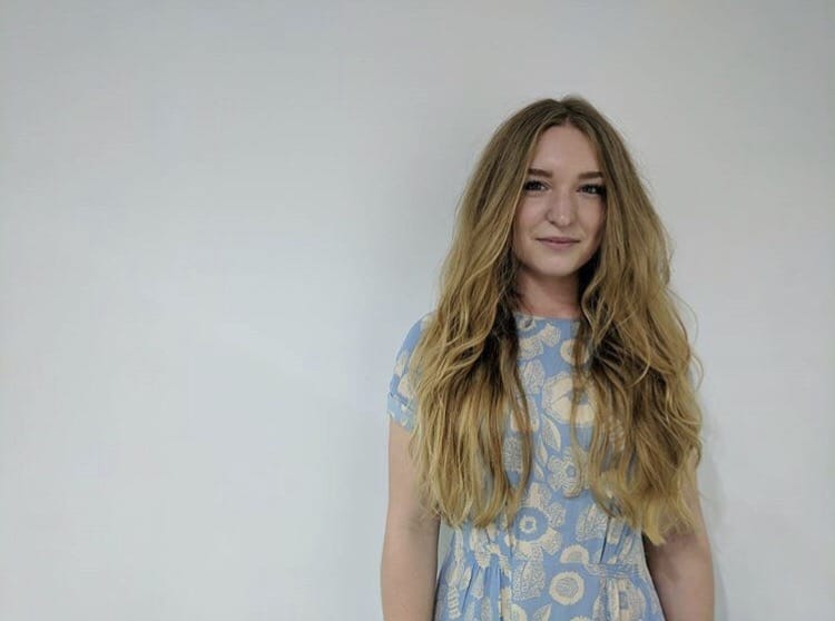 woman smiling with long, blonde and wavy hair