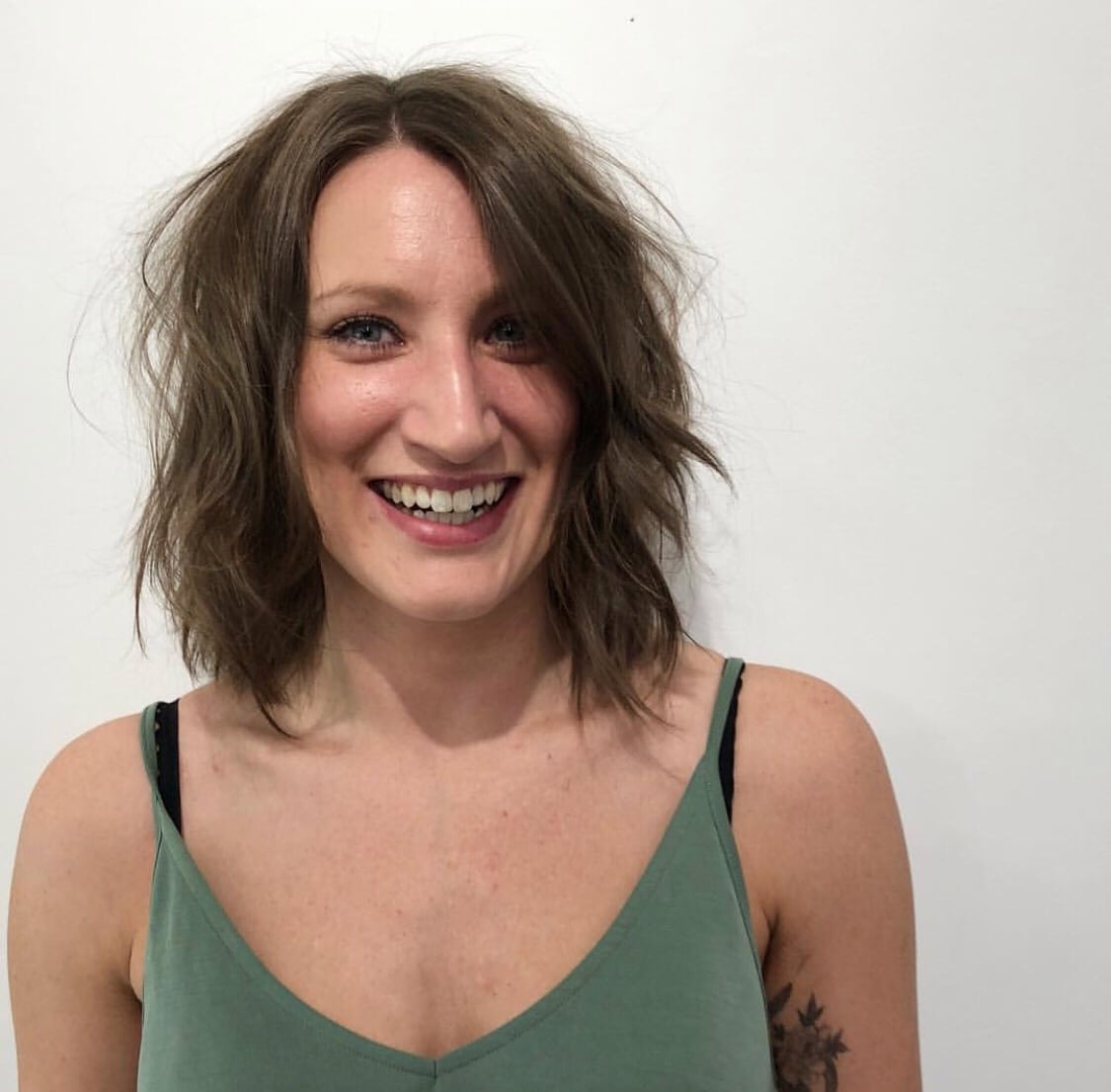 woman smiling with a short and wavy hairstyle