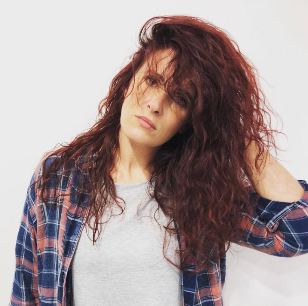 woman posing with long, red and curly hair