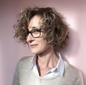 woman wearing glasses with short curly hair