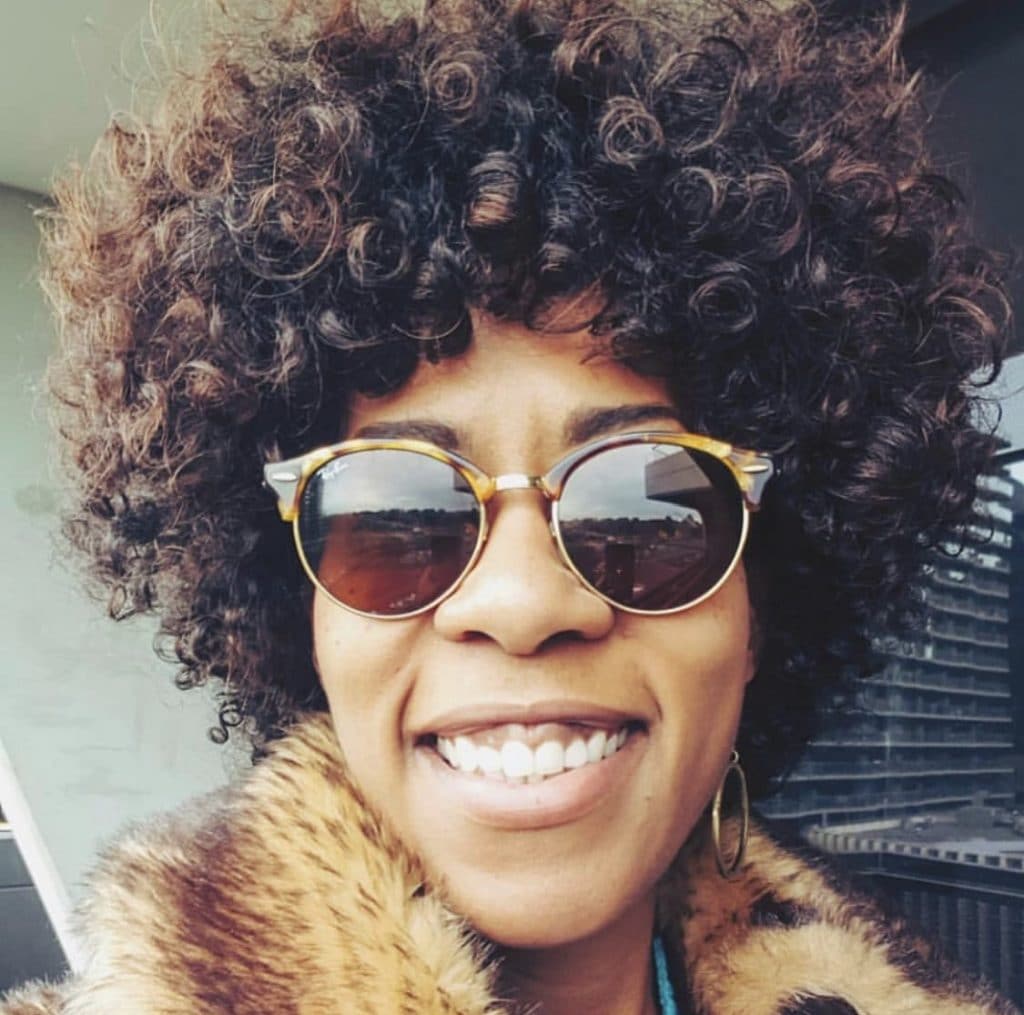 woman smiling wear sunglasses with short curly hair